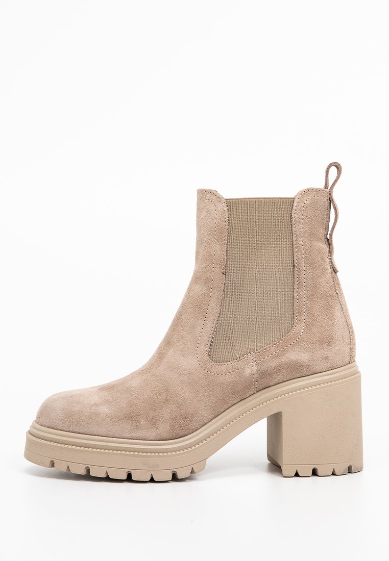 Beige Wildleder-Ankle-Boots mit einem klobigen Absatz, elastischen Seitenpaneelen und einer Ziehschlaufe an der Rückseite. Mit einer strukturierten Sohle für besseren Halt.
