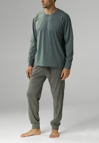 Szara, długosleeve'owa koszulka z bawełnianego materiału, z okrągłym dekoltem; zestawiona z szarymi spodniami dresowymi z elastycznymi mankietami i sznurkiem do regulacji.