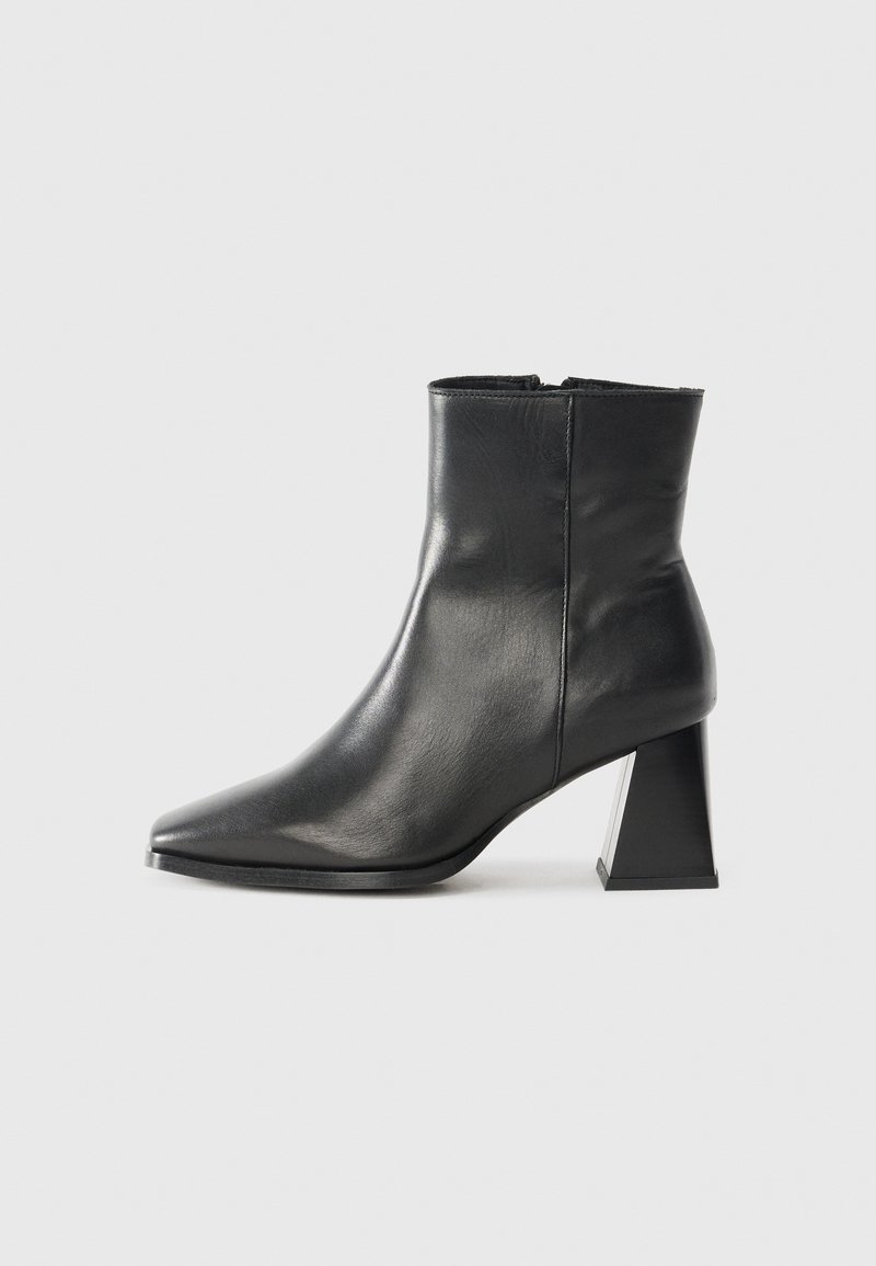 Black leather ankle boot with pointed toe and a chunky, geometric block heel. Smooth texture and minimal design without visible hardware.