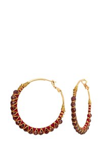 Boucles d'oreilles en or en forme de créole, entourées de fil rouge et ornées de perles facettées de couleur rouge foncé et d'accents en fil croisé doré.