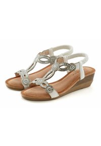 Witte wedge sandalen met een gestructureerde binnenzool. Decoratieve zilveren versieringen op de banden. Elastische achterkant voor een veilige pasvorm. Duurzame zool.
