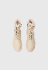 Beige ankelstøvler med en teksturert, faux fur-krage, lær øvre del, rund tå og glidelås på siden. Snøring med forsterkede hull.
