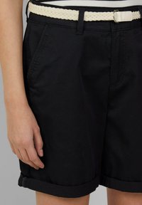 Shorts noirs en mélange de coton, dotés d'une ceinture tressée crème, de poches latérales et de poignets retroussés pour un look décontracté.