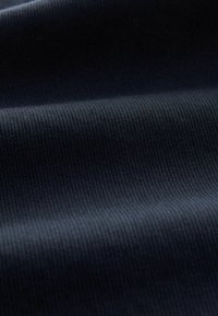 Dunkelblauer Stoff mit einer gerippten Textur, der horizontale Rillen aufweist. Das Material wirkt weich und flexibel, geeignet für verschiedene Anwendungen.