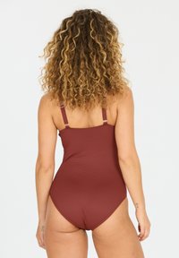Maillot de bain une pièce bordeaux avec des bretelles réglables et un tissu texturé. Présente un dos nu et un design sans coutures pour plus de confort.
