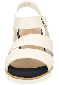 Sandale blanche à lanières avec une sangle de cheville réglable, semelle intérieure en cuir bleu rembourrée et semelle texturée, dotée d'un talon plat et de quincaillerie dorée.