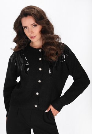 Schwarzer Wollcardigan mit Paillettenakzenten auf den Schultern, rundem Halsausschnitt und silbernen Knöpfen auf der Vorderseite. Strukturierter Strickstoff.