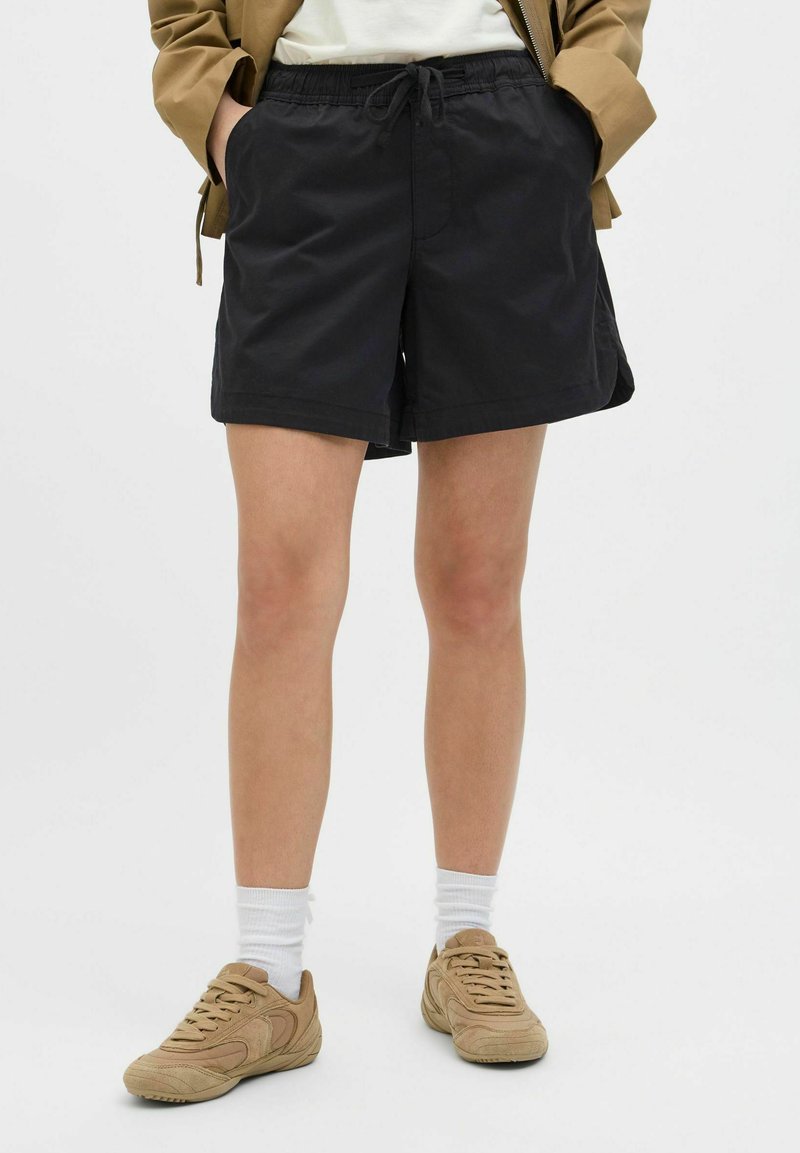 Shorts negros hechos de tejido ligero, con una cinturilla elástica y cordón, bolsillos laterales y un corte holgado.