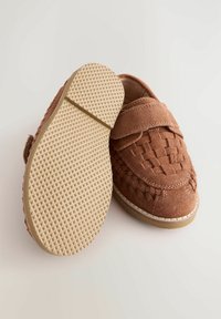 Braune Wildlederschuhe mit einem geflochtenen Design, ausgestattet mit einem Klettverschluss. Strukturiertes Gummisohle mit geometrischem Muster. Robuster und lässiger Stil.