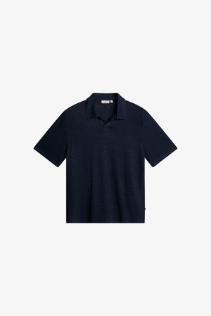 Polo à manches courtes bleu marine avec col et petite étiquette de marque sur le col et la couture latérale.