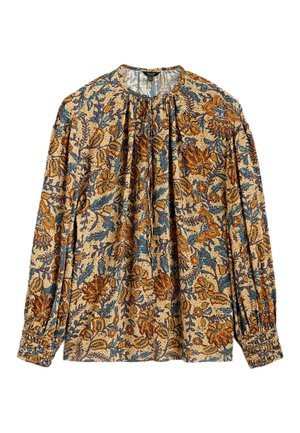 Blouse beige à manches longues avec des motifs floraux et de feuilles bleus, bruns et orange, col et poignets froncés.