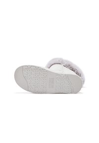 Botte blanche avec une semelle lisse et texturée présentant un motif de relief. La tige est dotée d'une doublure grise douce et duveteuse ainsi que d'accents autour de l'ouverture.