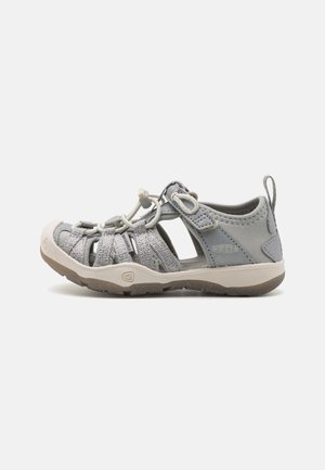 Scarpe da acqua grigie con pannelli in rete traspirante, lacci elastici e suola in gomma. Presentano una vestibilità sicura e un tallone rinforzato per la stabilità.