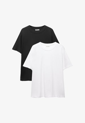 Dve kratkodolge majice, ena črna in ena bela, izdelani iz mehkega materiala s krožnim ovratnikom in sproščenim krojem. Brez vzorcev ali okraskov.