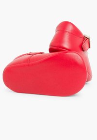 Botín de cuero rojo hasta el tobillo con puntera redondeada, textura lisa y una correa ajustable en el lateral. Suela suave y flexible para mayor comodidad.