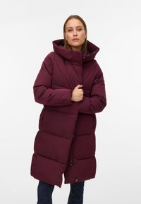 Bordový péřový kabát s vysokým límcem, velkou kapucí a zapínáním na knoflíky. Má prošívaný design a boční kapsy. Vhodný do chladného počasí.