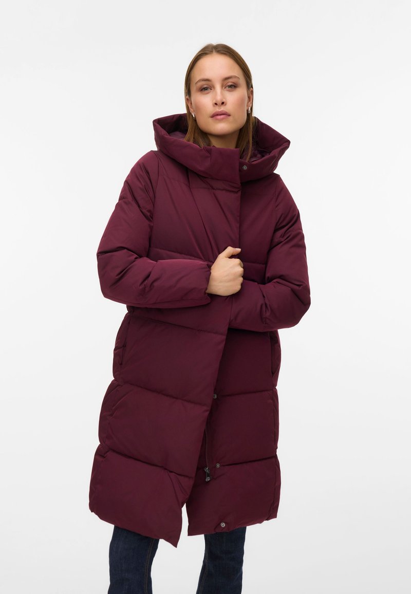 Bordový péřový kabát s vysokým límcem, velkou kapucí a zapínáním na knoflíky. Má prošívaný design a boční kapsy. Vhodný do chladného počasí.