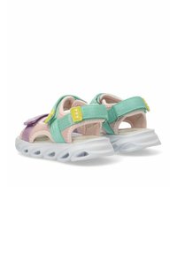 Sandalias coloridas con parte superior de tela en verde menta y rosa claro, correas ajustables y suela de goma translúcida con amortiguación de aire.