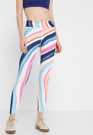 Leggings multicolores avec de larges rayures ondulées en bleu, rose, orange et blanc. Taille élastique ; design ajusté ; texture lisse.