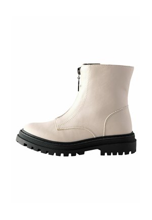 Beiger Leder-Stiefelette mit schwarzer dicker geriffelter Sohle und Front-Reißverschluss, Seitenprofil auf weißem Hintergrund.