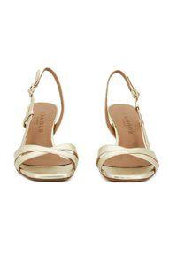 Sandali slingback in metallo dorato con cinturini incrociati sul davanti, punta aperta, tacco sottile e soletta con marchio per un tocco di dettaglio.