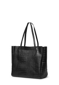 Svart tote-väska i krokodilsmönstrad läder, med två långa handtag och en strukturerad form med varierande texturer på ytan.