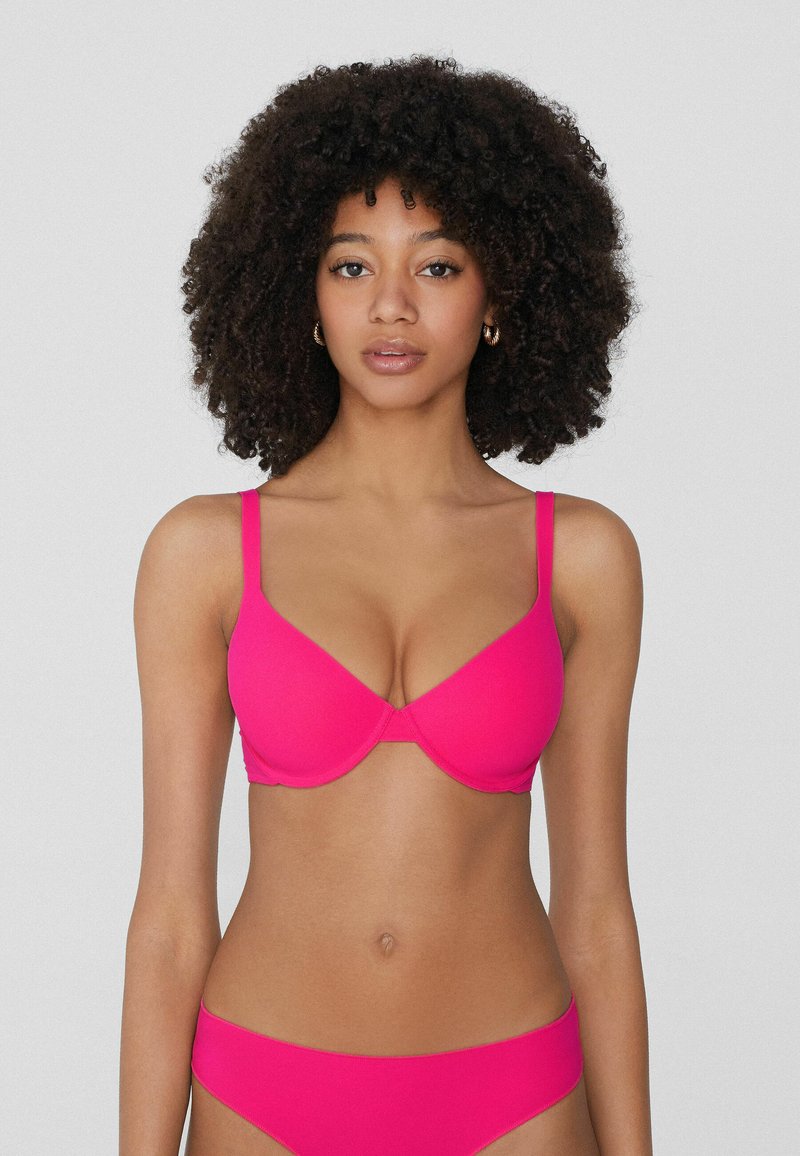 Světlý růžový bikinový set s tvarovanou podprsenkou a nastavitelnými ramínky, doplněný o odpovídající vysoké kalhotky, obojí vyrobené z hladkého a pružného materiálu.