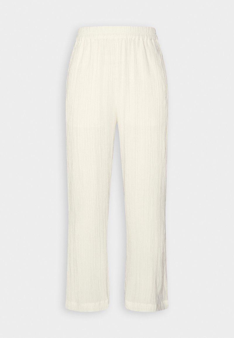 Pantalon blanc texturé, coupe ample, avec taille élastique et jambes droites sur un fond clair uni.