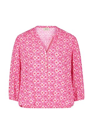 Blouse rose avec un motif géométrique et des accents blancs, sans col, à manches trois-quarts, et un devant boutonné.