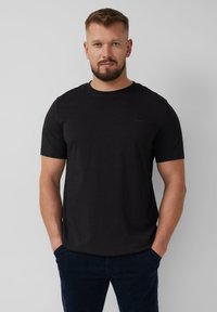Zwarte, korte mouwen t-shirt van katoen met een ronde hals. Heeft een subtiele logo op de borst en een relaxte pasvorm.
