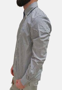 Camicia a righe blu e bianca, con maniche lunghe e colletto; realizzata in un tessuto leggero; presenta un piccolo logo sul petto.