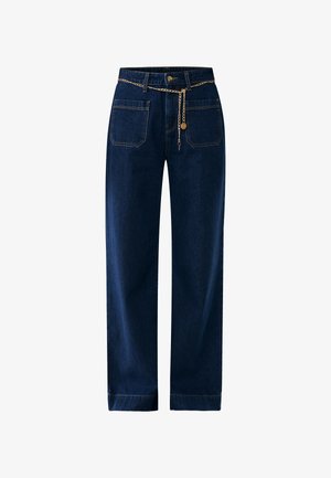 Tmavě modré džíny rovného střihu, s opaskem se zlatým řetízkem a tradičním pětikapsovým designem.