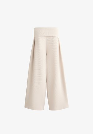 Beige weit geschnittene Hosen mit einem flachen Bund, strukturiertem Stoff und plissierten Details, die einen lockeren Schnitt bieten und bis zur Mitte der Wade reichen.