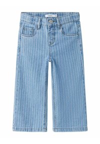 Pantalones de mezclilla azul claro con un patrón de rayas verticales en blanco y tonos pastel, cinco bolsillos y cierre de botón de metal en la cintura.