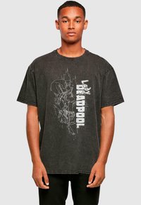 Sort oversized t-shirt med grafisk print af Lady Deadpool. Har rund halsudskæring, korte ærmer og distressed tekstur.