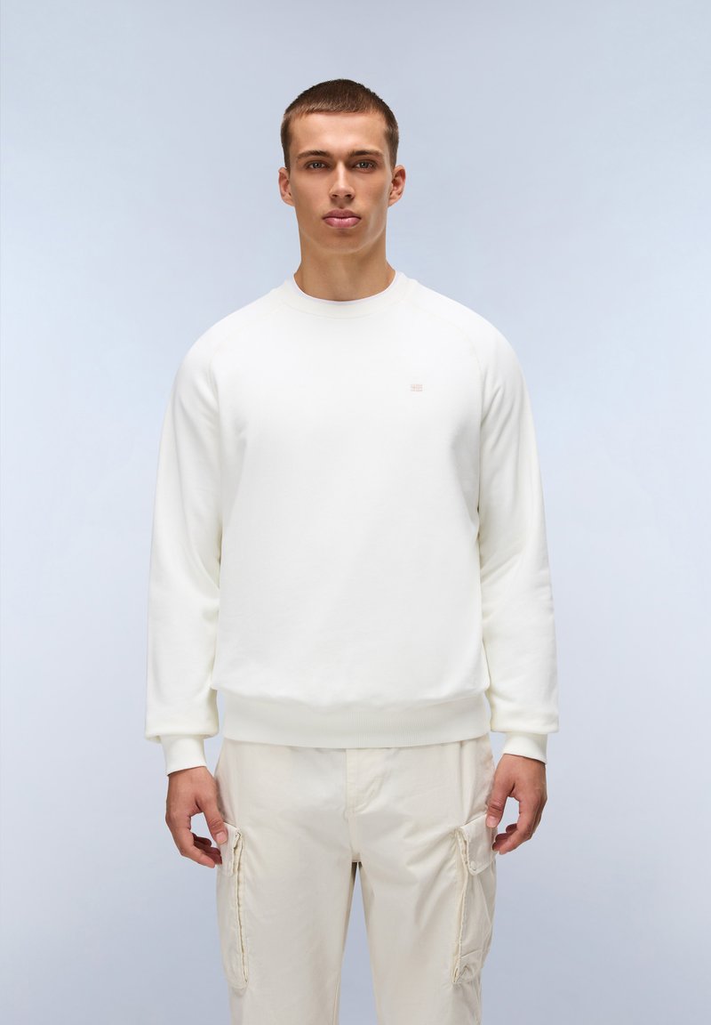Felpa bianca a girocollo realizzata in misto cotone, con polsini e orlo a costine, abbinata a pantaloni cargo beige. Logo semplice sul petto.