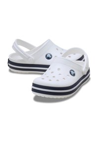 Białe klapki z bocznymi otworami, tylnym paskiem i podwójnymi granatowymi paskami na podeszwie. Wykonane z lekkiego materiału, z okrągłym noskiem.