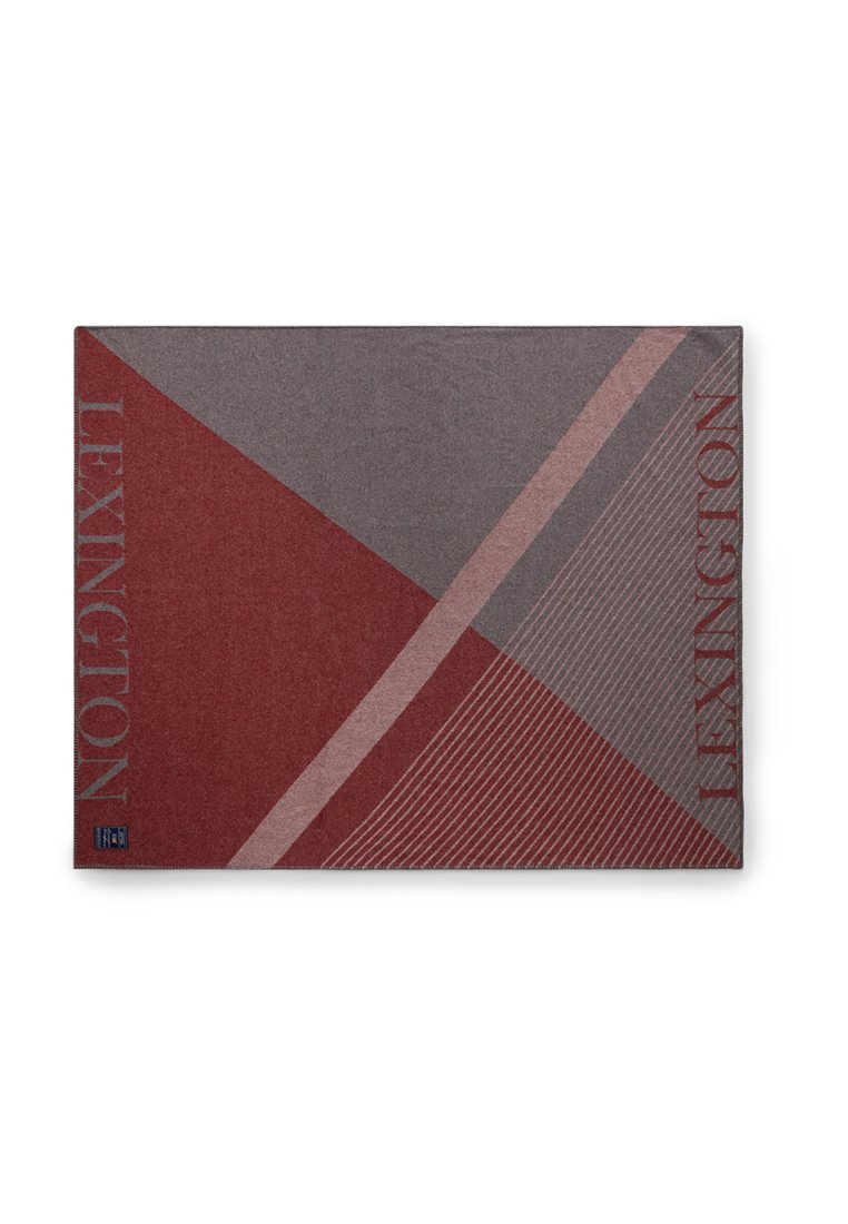 Rood en grijs dekentje met geometrisch patroon en strepen, met de tekst "LEXINGTON" aan de zijkant, gemaakt van zachte stof.