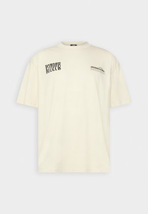 Ecrufarbenes kurzärmeliges T-Shirt mit kleinem schwarzem abstraktem Textdesign auf der linken Brust und verzerrtem Text auf der rechten Brust.