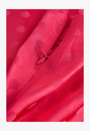 Heledast roosa kangas, sileda tekstuuriga, millel on reljeefsed täpilised mustrid. Ühel serval paistab peidetud tõmblukk.