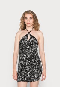 Vestido preto de decote halter com uma abertura em forma de buraco de chave, apresentando um padrão floral branco, textura franzida e silhueta ajustada.