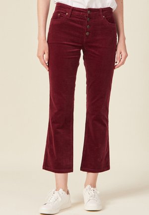 Bordeaux corduroy broeken met een rechte pijpdesign, vijf-knopen frontsluiting en voorzakken. Gepaard met witte sneakers.