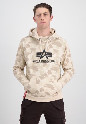 Beige Hoodie mit Camouflage-Muster, Kordelzugkapuze, Kängurutasche und schwarzem "Alpha Industries" Logo auf der Vorderseite.