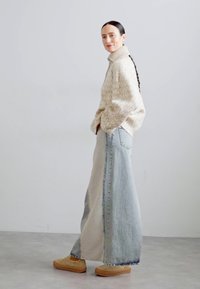 Beige mönstrad tröja, parat med en lång, ljusblå denimkjol. Har hög midja och två sidfickor. Bruna skor fulländar looken.