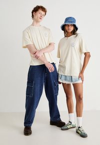 Jack & Jones JORREALMEAL TEE UNISEX - T-shirts med print - buttercream