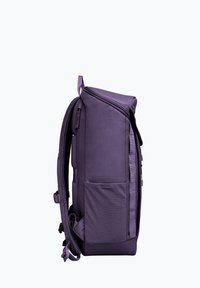 Sac à dos violet en tissu lisse et durable, avec une poche latérale, des bretelles rembourrées et une forme structurée. Fermeture à glissière en haut.