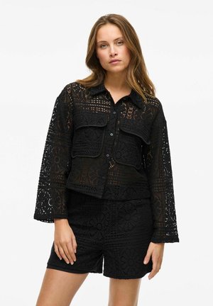 Schwarze Spitzenjacke mit zwei Vordertaschen, langen Ärmeln und einem Kragen, die komplizierte Blumenmuster aufweist und in cropped Gestaltung gehalten ist.