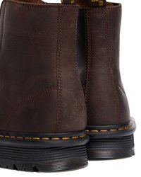 Brune lær ankle støvler med en glat tekstur, gule syninger og solide gummisåler. Har en sømdetalj langs hver side.