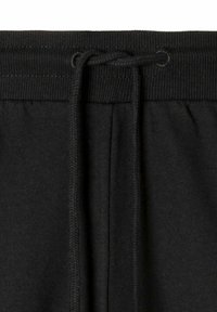 Schwarze Jogginghose mit einem gerippten elastischen Bund und Zugband. Weiches Baumwollmaterial mit seitlichen Taschen und gestickten Details.