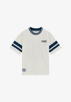 Fehér rövid ujjú póló tengerészkék dupla csíkokkal az ujjakon, tengerészkék gallér szegéllyel, a mellkason "GAME CHANGERS" felirattal és egy kis folttal a szegély közelében.